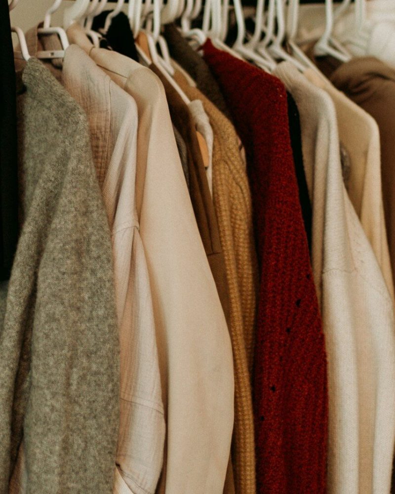 brown and white coat hanged on rack